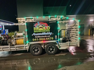 Mold Munchers branded pressure washing trailer at night — Sarasota FL