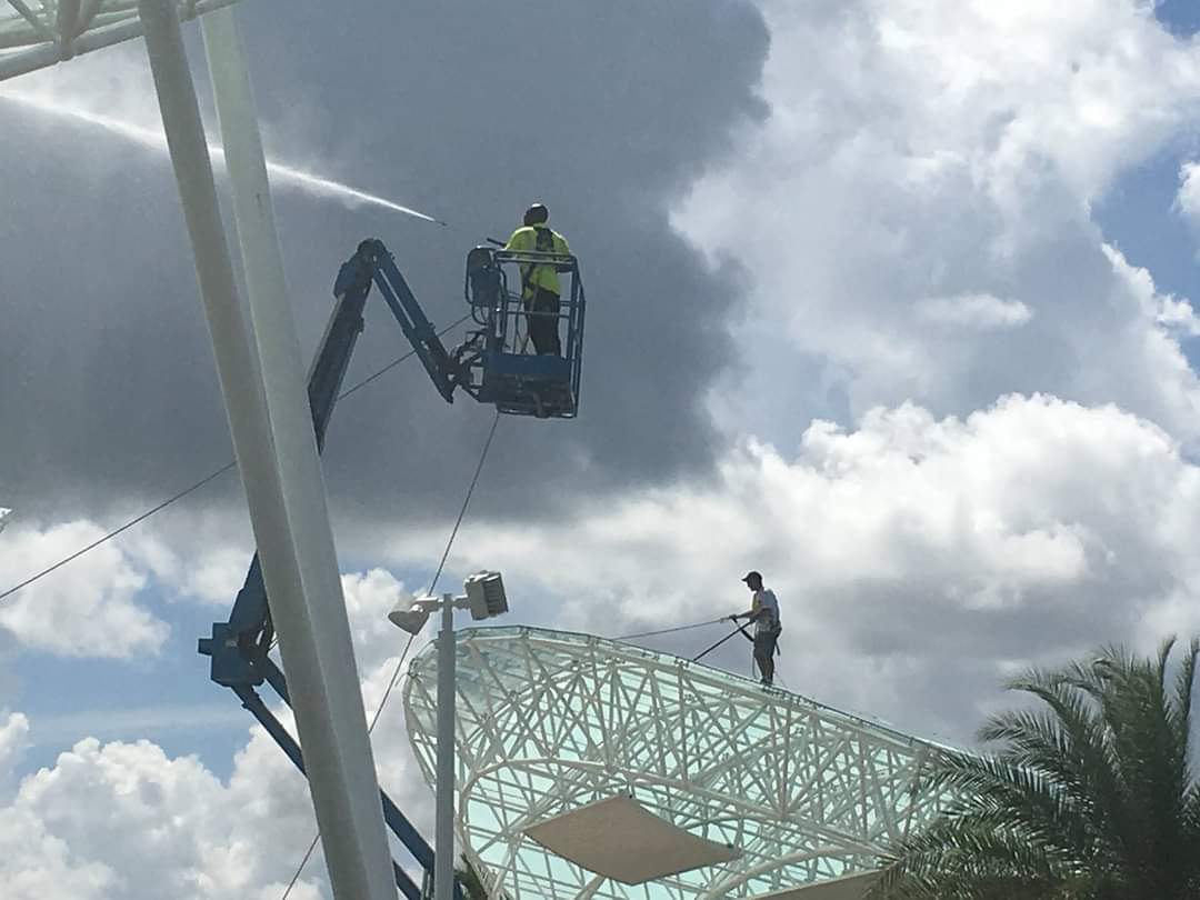 Boom lift and ground crew cleaning Sarasota National Cemetery amphitheater structure